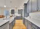 Bright, open kitchen with a farmhouse sink, gray cabinets, and hardwood floors at 8894 River Peak Cir, Littleton, CO 80125