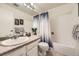 Clean bathroom with a bathtub, shower curtain, a toilet, and a mirrored vanity at 7925 W Layton Ave # 529, Littleton, CO 80123