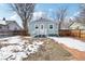 Fenced backyard with patio and partial snow cover at 922 Pratt St, Longmont, CO 80501