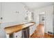 Bright kitchen with wooden countertop, stainless steel dishwasher, white cabinets, and hardwood floors at 922 Pratt St, Longmont, CO 80501