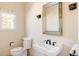 Cozy bathroom featuring a pedestal sink, toilet, decorative mirror, and sconces at 5184 Pinyon Jay Rd, Parker, CO 80134