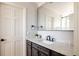 Chic bathroom features a vanity with sleek hardware, a large mirror, and marble-tiled shower at 5184 Pinyon Jay Rd, Parker, CO 80134