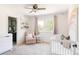 Bright Bedroom with white crib, changing table, soft pink glider, and large window with backyard views at 5184 Pinyon Jay Rd, Parker, CO 80134