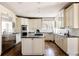 Bright kitchen with white cabinets, stainless steel appliances, a center island, and modern countertops at 5184 Pinyon Jay Rd, Parker, CO 80134