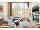 Spacious living room with fireplace, mantle, large sectional couch, and large windows at 5184 Pinyon Jay Rd, Parker, CO 80134