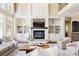 Comfortable living room with fireplace, built-in shelves, and large windows for natural light at 5184 Pinyon Jay Rd, Parker, CO 80134