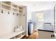 Practical mudroom with storage shelves, bench, coat hooks and convenient sink and laundry at 5184 Pinyon Jay Rd, Parker, CO 80134