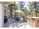 Outdoor dining space with an umbrella-covered table, chairs, and a grill, all situated on a wooden deck at 5184 Pinyon Jay Rd, Parker, CO 80134
