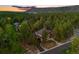 Stunning aerial view of the home nestled among lush trees and the surrounding scenic landscape at 7737 Taylor Cir, Larkspur, CO 80118