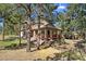 Charming home surrounded by mature trees, showcasing a welcoming porch and well-maintained landscaping at 7737 Taylor Cir, Larkspur, CO 80118