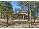 Beautiful home nestled among mature trees, featuring a spacious porch for outdoor enjoyment at 7737 Taylor Cir, Larkspur, CO 80118
