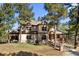 Beautiful two-story home with a manicured lawn and mature trees offering a serene and private setting at 7737 Taylor Cir, Larkspur, CO 80118