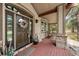 Inviting front porch with rocking chairs, stone pillars, and a beautifully decorated front door at 7737 Taylor Cir, Larkspur, CO 80118