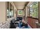 Charming covered porch with stylish outdoor seating and views of the lush backyard at 7737 Taylor Cir, Larkspur, CO 80118