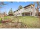 Lovely backyard with lush green lawn, garden beds, and a charming two-story home with a balcony at 2961 S Rosemary St, Denver, CO 80231