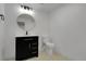 Bathroom featuring a dark vanity, mirror, and toilet at 2961 S Rosemary St, Denver, CO 80231