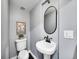 Charming powder room features an oval mirror, pedestal sink, and stylish fixtures at 240 Colorado Blvd, Denver, CO 80206