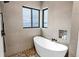 Bright bathroom with a soaking tub beneath corner windows and unique tile accents in the shower at 202 October Pl, Castle Rock, CO 80104