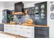 Modern kitchen with contrasting cabinetry, butcher block countertops, and a black range hood at 202 October Pl, Castle Rock, CO 80104