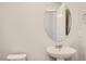 Clean bathroom with a pedestal sink and oval mirror at 6942 Huddersfield Ln, Castle Pines, CO 80108