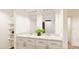 Well-lit bathroom with double sinks, white cabinetry, quartz counters, and linen shelving at 22361 E 38Th Pl, Aurora, CO 80019