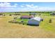 Wide aerial view of the property showcasing the house, workshop, RV, fenced garden, and surrounding landscape at 177 W 8Th Ave, Byers, CO 80103
