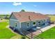 Rear view of a house with a concrete patio including dining and seating, overlooking a spacious, grassy backyard at 177 W 8Th Ave, Byers, CO 80103