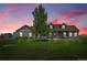 Charming single-story home with lush lawn, mature trees, and gray siding at dusk at 177 W 8Th Ave, Byers, CO 80103