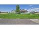 Single-story home with lush lawn, mature trees, gray siding, and storage shed at 177 W 8Th Ave, Byers, CO 80103