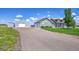 Charming home with a long driveway, manicured lawn, and a detached garage or workshop at 177 W 8Th Ave, Byers, CO 80103