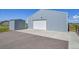 Large gray metal outbuilding with a wide driveway and an additional storage building at 177 W 8Th Ave, Byers, CO 80103