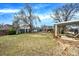 Large backyard featuring a patio, a fire pit, and mature trees against a blue sky at 1565 S Helena Cir, Aurora, CO 80017