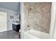 Accessible bathroom featuring a walk-in tub with a shower, safety bars, and a modern vanity area at 1565 S Helena Cir, Aurora, CO 80017
