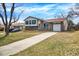Charming split-level home with a brick and siding exterior, well-kept lawn and an attached garage at 1565 S Helena Cir, Aurora, CO 80017