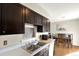 Bright kitchen featuring dark wood cabinets, a stainless steel sink, and modern appliances at 1565 S Helena Cir, Aurora, CO 80017