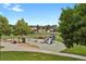 A community playground featuring slides and climbing structures, surrounded by lush green grass and trees at 1276 S Zeno Cir # A, Aurora, CO 80017