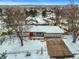 Aerial front view of a home with a driveway and a red front door, surrounded by snow-covered landscaping at 7250 W Vassar Ave, Lakewood, CO 80227