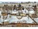 A large, partially snow-covered backyard with a patio and a two-story house at 7250 W Vassar Ave, Lakewood, CO 80227