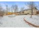 Expansive snowy backyard with terraced landscaping and a spacious deck, perfect for outdoor entertaining at 7250 W Vassar Ave, Lakewood, CO 80227