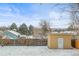 Spacious backyard showcasing a storage shed, a privacy fence, and snow-covered ground, perfect for outdoor activities at 7250 W Vassar Ave, Lakewood, CO 80227