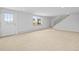 Finished basement space with a door, window, stairs, and neutral carpet at 7250 W Vassar Ave, Lakewood, CO 80227