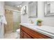 Bathroom showcasing double sinks, dark wood cabinets, and glass shower at 7250 W Vassar Ave, Lakewood, CO 80227