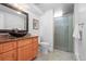 Stylish bathroom featuring a vessel sink, granite countertop, and a tiled shower with a glass door at 7250 W Vassar Ave, Lakewood, CO 80227