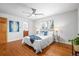 Inviting bedroom with wood floors, a ceiling fan, and ensuite bathroom access at 7250 W Vassar Ave, Lakewood, CO 80227