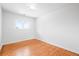 Well-lit empty bedroom with hardwood floors, a window, and base trim at 7250 W Vassar Ave, Lakewood, CO 80227