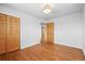 Empty bedroom with hardwood flooring, double door closet, and two entry points at 7250 W Vassar Ave, Lakewood, CO 80227