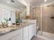 Bathroom featuring double vanity, granite countertop, and a glass-enclosed shower with neutral tile at 1649 Marquette Aly, Erie, CO 80516