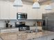 Well-lit kitchen features stainless steel appliances, granite counters, and white cabinetry at 1649 Marquette Aly, Erie, CO 80516