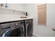 Modern laundry room with side by side washer and dryer and convenient storage at 1649 Marquette Aly, Erie, CO 80516
