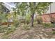 Green backyard featuring a large tree, wooden fence, and garden gate at 7198 Eaton Ct, Arvada, CO 80003